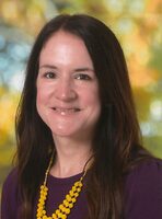 A woman with long hair and a purple shirt.