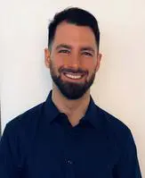 A man with a beard and smiling for the camera.